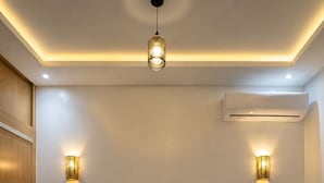Et soveværelse med en stor seng, to sengeborde, en loftlampe og en aircondition.