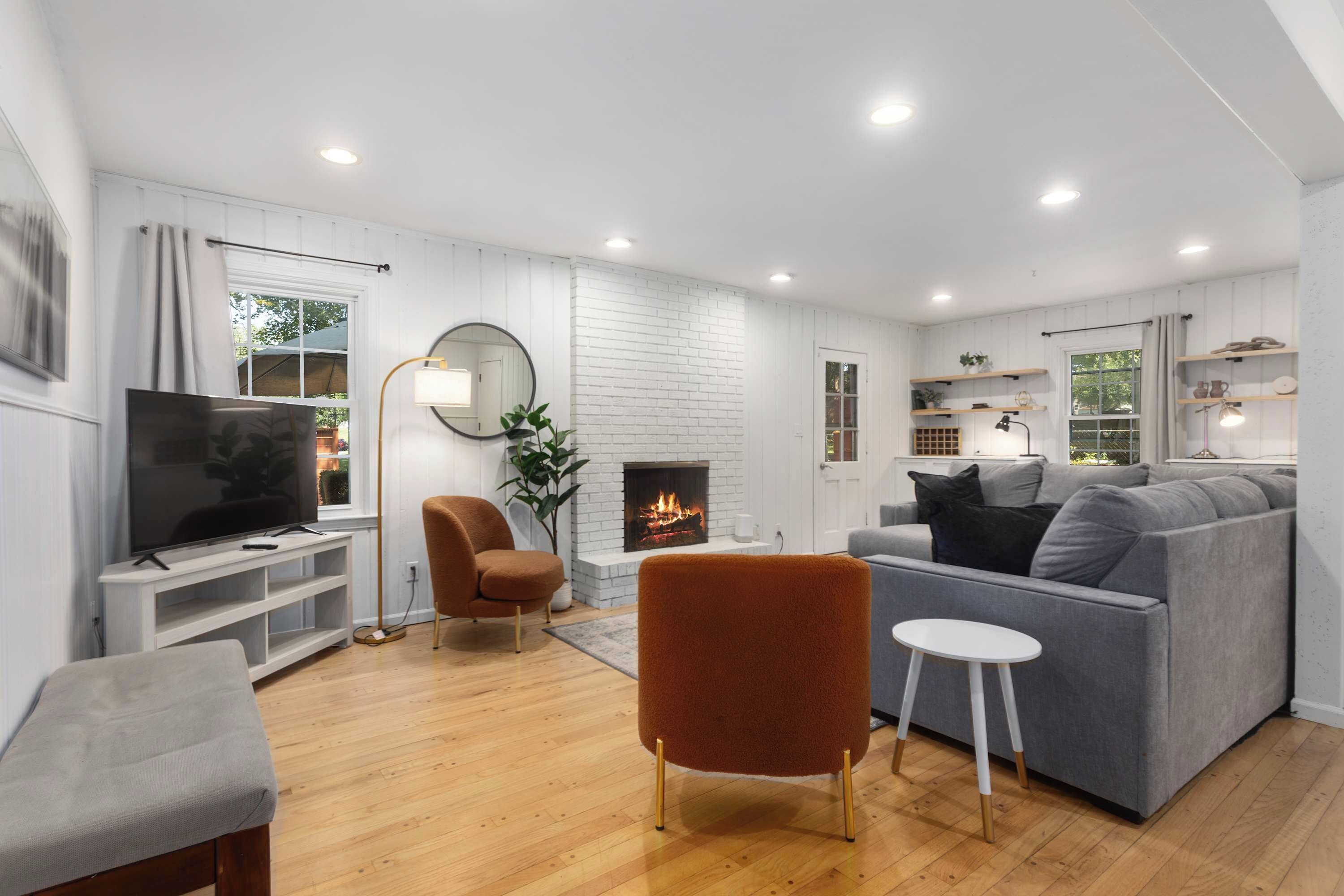 A modern living room with a fireplace, a television, and seating arrangements.