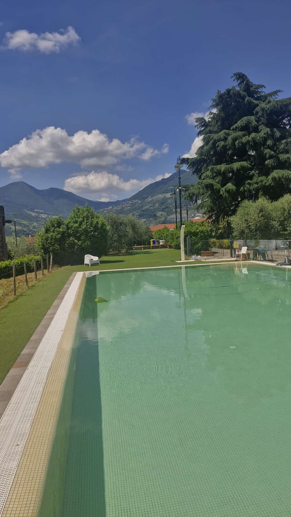 A swimming pool with a clear view of the surrounding landscape, including mountains and trees.