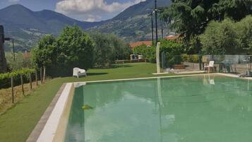 A swimming pool with a clear view of the surrounding landscape, including mountains and trees.