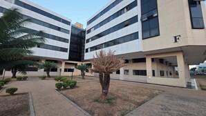 Un edificio moderno con fachada plana, varios pisos y la letra 'F' en el lateral.