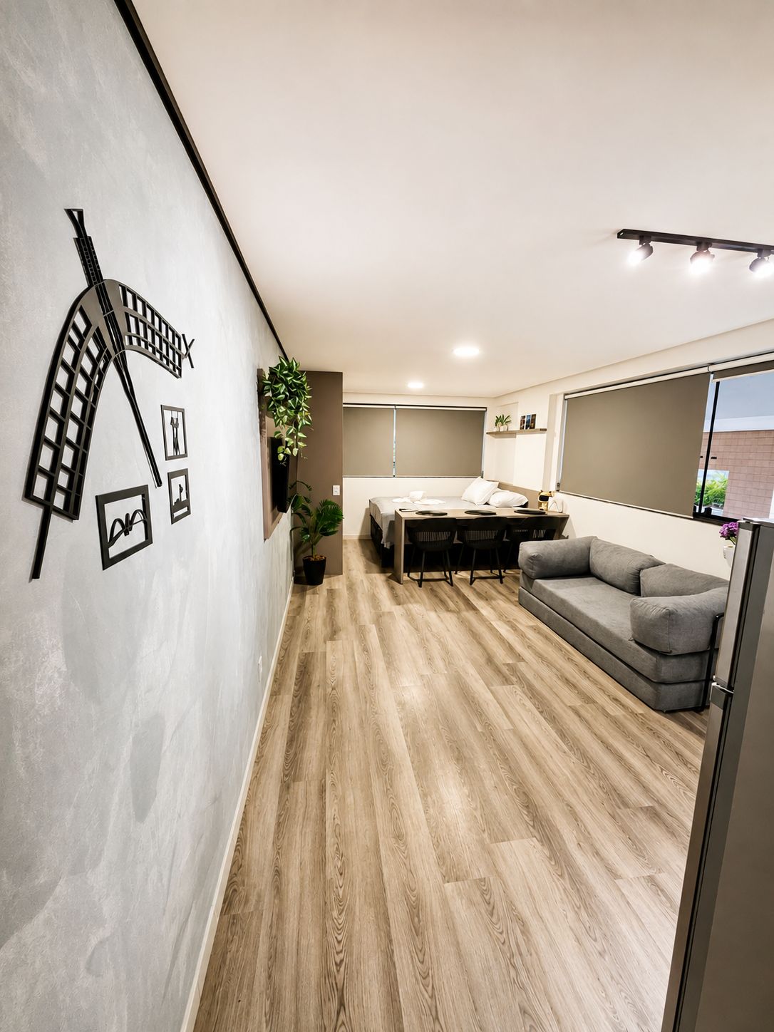 A modern interior with a dining area, sofa, and a wall-mounted light fixture.