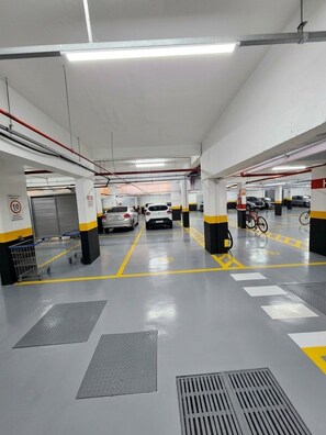 A multi-level parking garage with clear signage, designated parking spaces, and a bicycle parked in one of the spots.