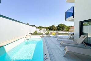 A rooftop pool area with lounge chairs and a clear view of the surrounding landscape. - 3-BR Villa with Private Pool Near the Beach (Zaton)
