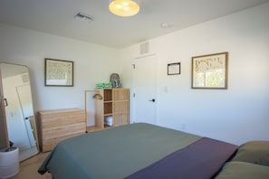 A bedroom with a bed, a wardrobe, a mirror, and a door. - Modern 2BR/2BA • Pool • Parking • Near Beach / Victoria Park / Las Olas (Fort Lauderdale)