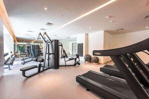 Ein Fitnessstudio mit Laufbändern, Kraftgeräten und Übungsbällen.