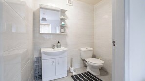 A modern bathroom with a white sink, toilet, and a mirror above the sink. - Farm Studio, Sleeps 5, Digital Disconnect (Ferns)