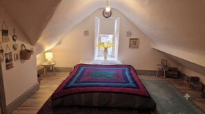 A cozy attic bedroom with a bed, a window, a lamp, and a small table. - Farm Studio, Sleeps 5, Digital Disconnect (Ferns)