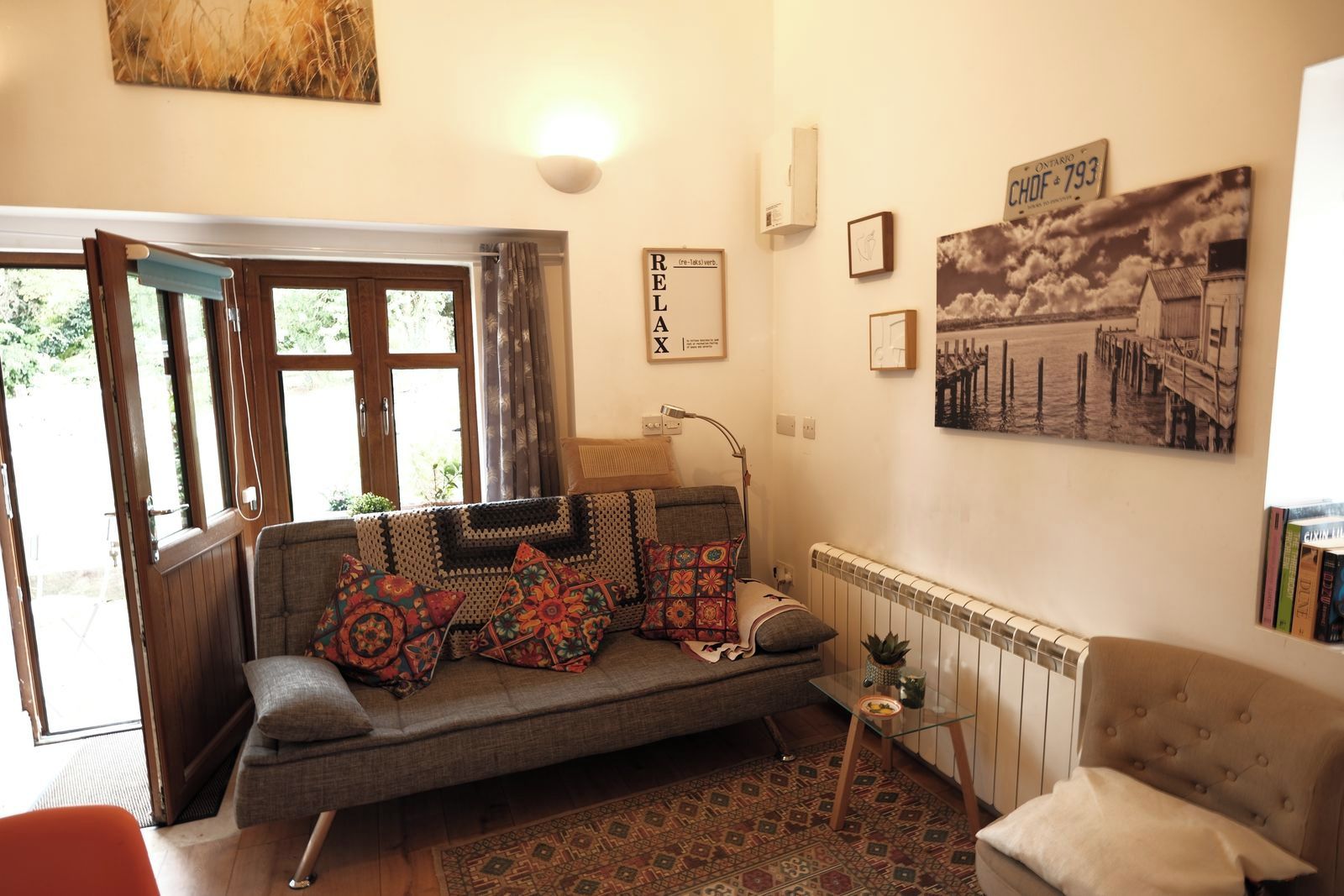 A cozy living room with a sofa, a small side table, and a radiator.