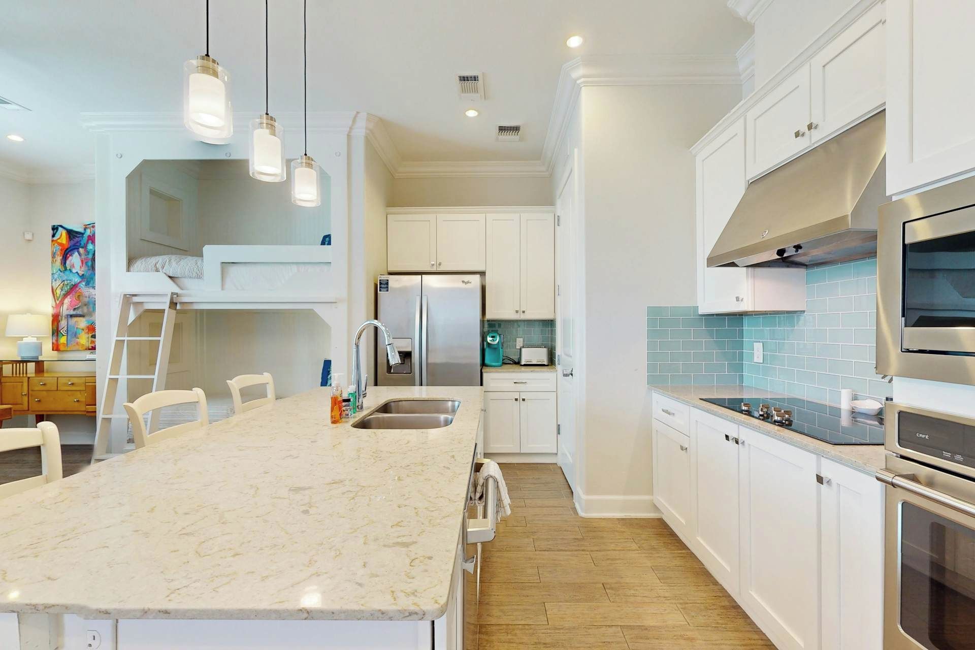 A modern kitchen with a central island, stainless steel appliances, and white cabinetry.