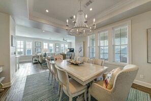 A spacious dining area with a chandelier, a large table, and multiple chairs. - Palmilla Beach | Steps to Beach | Resort Amenities (Port Aransas)