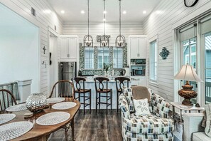 A spacious kitchen with white cabinetry, a central island, and pendant lighting. - Ca-SEA-ta | Steps to Beach | Resort Amenities (Port Aransas)