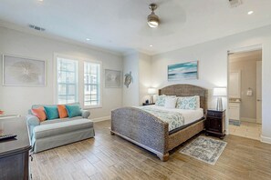 Une chambre avec un grand lit, un canapé et un bureau avec une lampe.