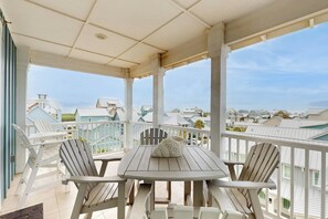 Ein überdachter Außenbereich mit Tisch und Stühlen mit Blick auf eine Wohngegend.