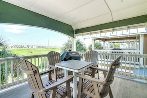 A covered outdoor seating area with a view of a golf course. - Top Of The Shoreline | Golf Views | Steps to Beach (Port Aransas)