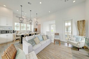 A spacious living area with a sofa, chairs, and a dining table. - Vida Del Mar | Steps to Beach | Resort Amenities (Port Aransas)