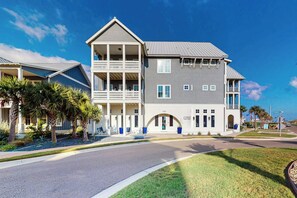 A two-story building with a balcony, a fitness center, and a street view. - We Be Beachin' | Golf Views | Pet Friendly (Port Aransas)