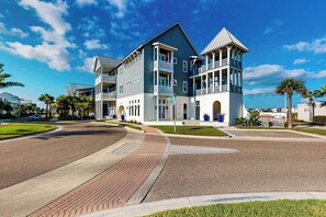 A two-story building with a balcony and a U-Haul truck parked outside. - We Be Beachin' | Golf Views | Pet Friendly (Port Aransas)
