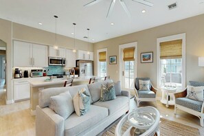 A modern kitchen with white cabinetry, stainless steel appliances, and pendant lighting. - We Be Beachin' | Golf Views | Pet Friendly (Port Aransas)