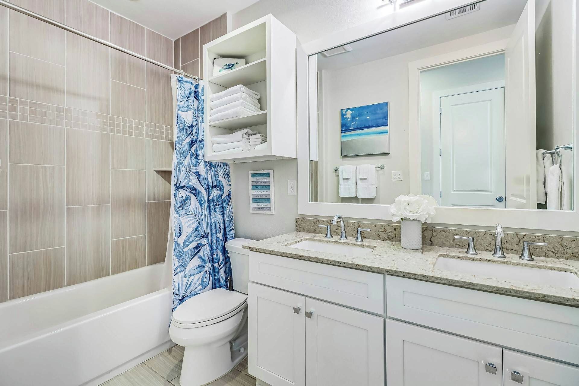 Une salle de bain avec une baignoire, des toilettes et un meuble-lavabo avec un miroir.