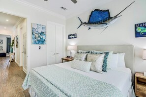 Ein Hotelzimmer mit Bett, Nachttisch, Lampe und Kunstwerken an den Wänden.