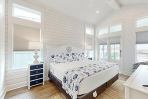 Ein Schlafzimmer mit Bett, Nachttischen und Blick ins Freie.
