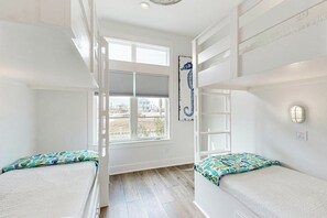 A room with bunk beds, a large window, and a seahorse artwork. - Palmilla Coastal Haven | Steps to Beach (Port Aransas)