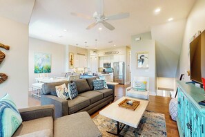 A modern living room with a sofa, coffee table, and a television. - Parrots Cove | Golf Views | Pet Friendly (Port Aransas)