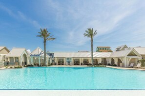 Ein Poolbereich mit klarem, blauem Pool, umgeben von Gebäuden im modernen Architekturstil.