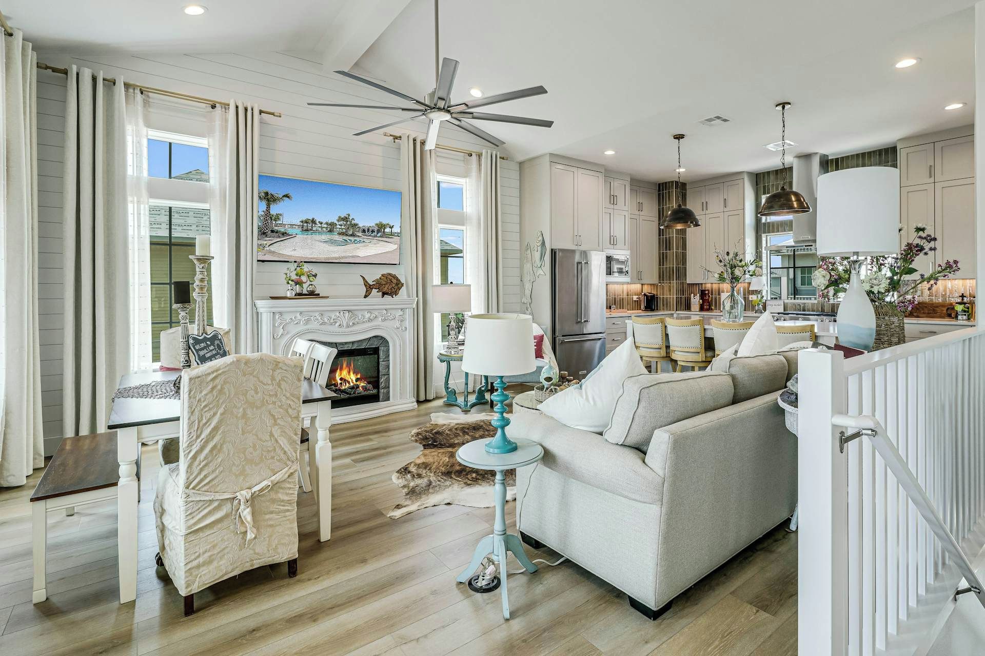A spacious living room with a fireplace, a dining area, and a kitchen.