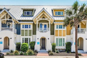 A multi-story hotel with balconies, a central entrance, and a well-maintained garden. - Sea Gem | Golf Views | Steps to Beach (Port Aransas)