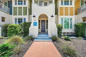 A multi-story building with a central entrance, numbered 120, surrounded by well-maintained landscaping. - Sea Gem | Golf Views | Steps to Beach (Port Aransas)
