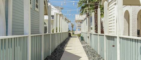 A pathway flanked by buildings with a clear sky above.