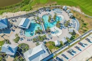 Vue aérienne d’un complexe hôtelier doté de plusieurs piscines, d’espaces de détente et d’un parking.