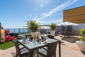 An outdoor dining area with a table set for breakfast, overlooking a body of water. - Villa Sunset Haven Adeje (Adeje)