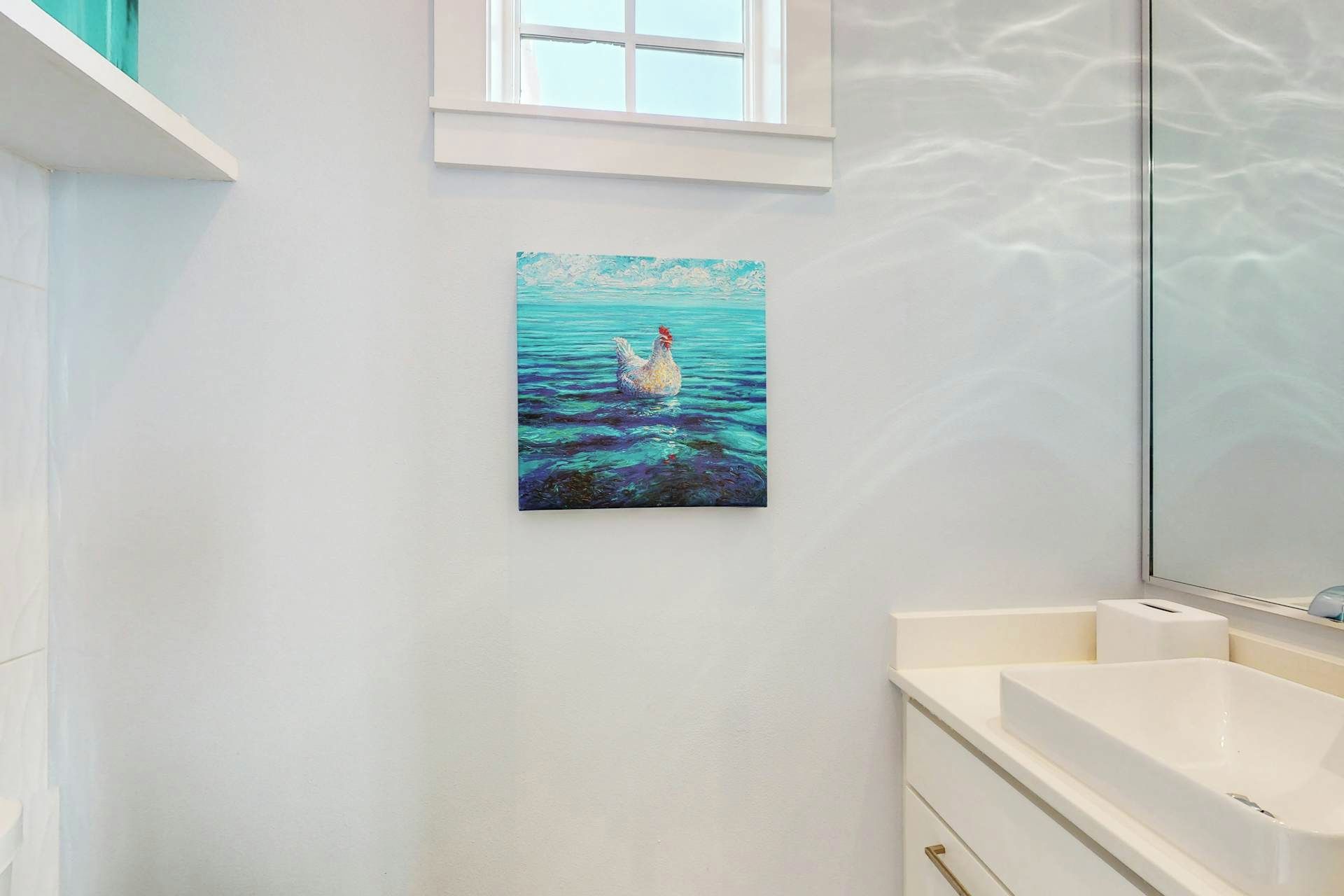 Ein Badezimmer mit einem weißen Waschbecken, einem Spiegel und einem Bild von einer Ente im Wasser.
