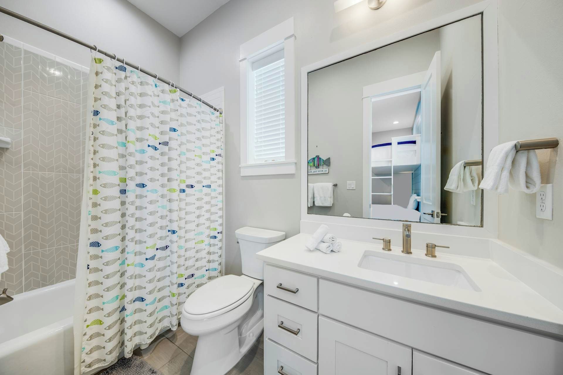 Un bagno con tenda della doccia, WC, lavandino e mobile lavabo.