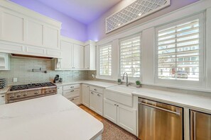 A kitchen with white cabinetry, a stainless steel dishwasher, and a gas stove. - Private Pool | Steps to Beach | Resort Amenities (Port Aransas)