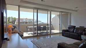 Un salon moderne doté d’une porte-fenêtre coulissante donnant sur un patio extérieur.