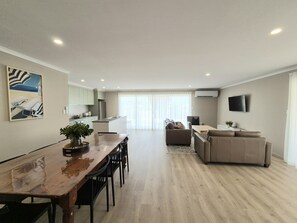 Un appartamento moderno con sala da pranzo, cucina, soggiorno e un'ampia finestra.