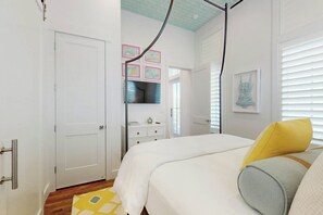 A bedroom with a bed, a dresser, a mirror, and a door. - Silverado Waves | Steps to Beach |Resort Amenities (Port Aransas)