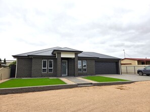 A modern two-story house with a garage, a well-maintained lawn, and a gravel driveway. - Belless at Moonta Bay, Moonta Bay (Moonta Bay)