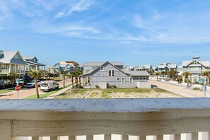 A coastal residential area with houses, a stop sign, and a van parked on the street. - Palmilla Beach CocoLoco| Gulf Views | Resort Perks (Port Aransas)