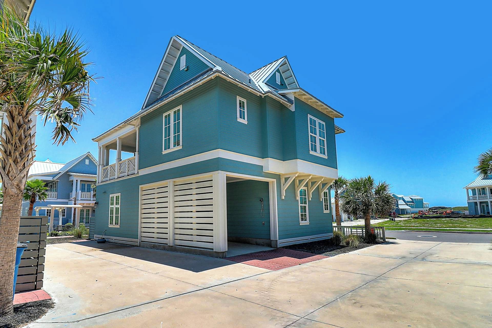 A two-story house with a garage, a balcony, and a clear blue sky.