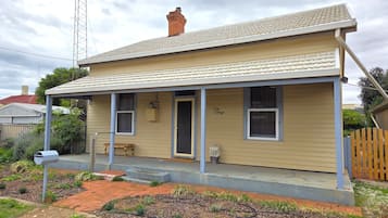 A single-story house with a porch, a chimney, and a mailbox.