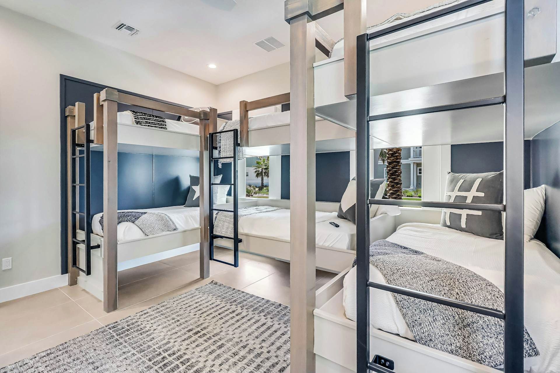 A modern hotel room with bunk beds, a large window, and a view of the outside.