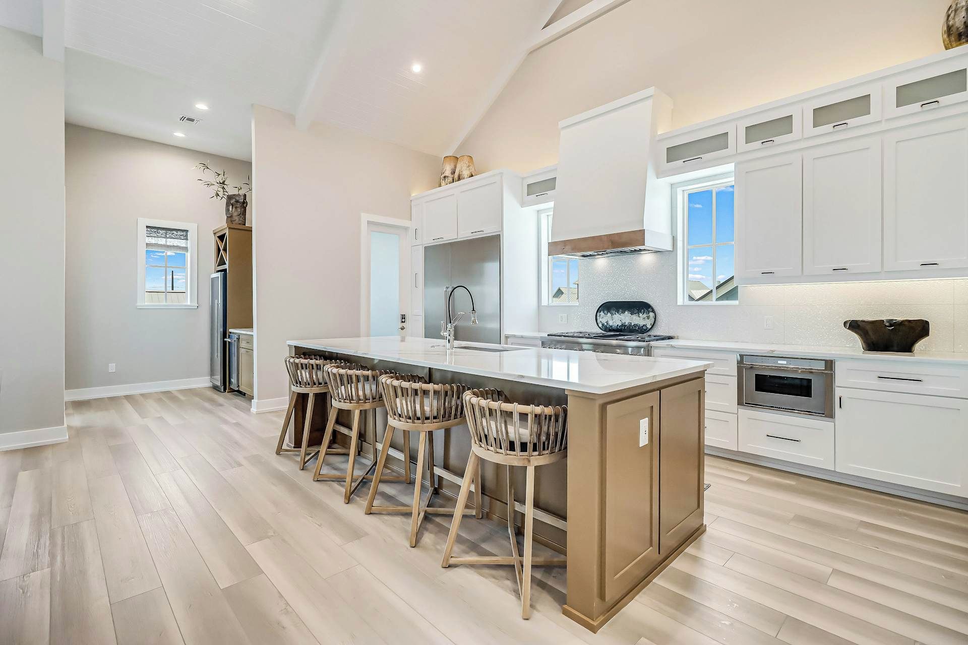 A spacious kitchen with a central island, bar stools, and modern appliances.