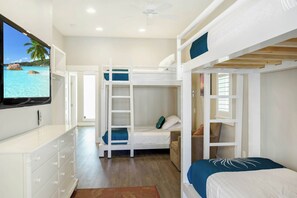A bunk bed room with a television on the wall, a desk, and a view of the sea. - Poolside Paradise | Gulf Views | Private Elevator (Port Aransas)