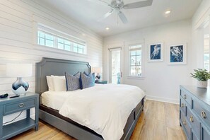 Ein Schlafzimmer mit einem Bett, Nachttischen, einer Kommode und Kunstwerken an den Wänden.