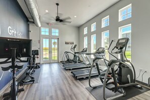 A gym with treadmills, elliptical machines, and a stationary bike. - Serenity Now | Gulf Views | Steps to Beach (Port Aransas)